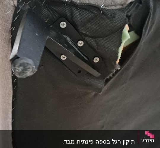 יד מחזיקה ריפוד ספה עם קרע בחלק התחתון